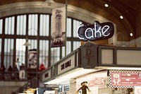 A “cake” neon over a store in a covered market. Original public domain image from Wikimedia Commons