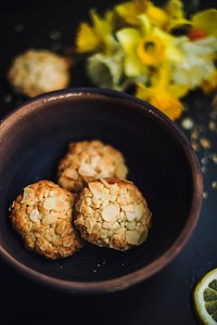 Almond cookies in a bowl with daffodils in the background. Original public domain image from <a href="https://commons.wikimedia.org/wiki/File:Cookie_Snacks_(Unsplash).jpg" target="_blank" rel="noopener noreferrer nofollow">Wikimedia Commons</a>