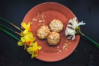 Overhead shot of fresh almond cookies plated with daffodils. Original public domain image from <a href="https://commons.wikimedia.org/wiki/File:Cookies_and_Flowers_(Unsplash).jpg" target="_blank" rel="noopener noreferrer nofollow">Wikimedia Commons</a>