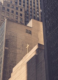 Cross on a simple concrete church building surrounded by high rise buildings. Original public domain image from <a href="https://commons.wikimedia.org/wiki/File:Cross_among_skyscrapers_(Unsplash).jpg" target="_blank" rel="noopener noreferrer nofollow">Wikimedia Commons</a>