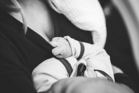 Black and white photo of mother holding baby in soft light. Original public domain image from Wikimedia Commons