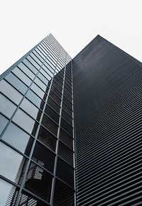 A corner of a modern office building facade with square glass windows. Original public domain image from Wikimedia Commons