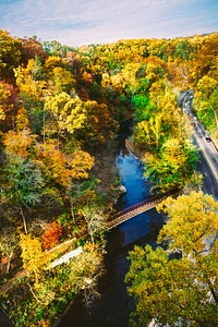 A drone shot of a small bridge over a river in an autumn scenery. Original public domain image from Wikimedia Commons