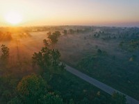 Drone view of misty countryside and through road at dawn-or-dusk in Flint, Michigan. Original public domain image from Wikimedia Commons