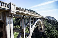 The side of a massive concrete bridge in a mountainous area. Original public domain image from Wikimedia Commons