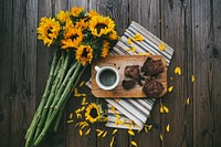 A bouquet of sunflowers, striped placemat, wooden board, cup of coffee, and brownies on a table. Original public domain image from Wikimedia Commons
