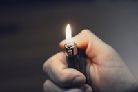 Person lighting a lighter. Original public domain image from Wikimedia Commons