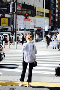 A woman is waiting at the crosswalk for the lights to turn green in Shibuya.. Original public domain image from Wikimedia Commons