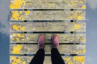 A person wearing burgundy color footwear walking on a fence style bridge. Original public domain image from <a href="https://commons.wikimedia.org/wiki/File:Narrow_walking_by_harbor_(Unsplash).jpg" target="_blank" rel="noopener noreferrer nofollow">Wikimedia Commons</a>