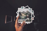 A person holding a bunch of Polaroid pictures with words on them in Seattle. Original public domain image from Wikimedia Commons