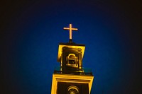 A lighted church steeple and cross against the dark blue night sky in Beirut.. Original public domain image from Wikimedia Commons