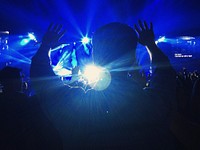 The silhouette of a person at a concert throwing their hands up in the blue light. Original public domain image from <a href="https://commons.wikimedia.org/wiki/File:Enjoying_the_concert_(Unsplash).jpg" target="_blank" rel="noopener noreferrer nofollow">Wikimedia Commons</a>
