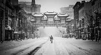 A man walking down a snow covered street in Chinatown in black and white. Original public domain image from <a href="https://commons.wikimedia.org/wiki/File:A_man_in_snowy_Chinatown_(Unsplash).jpg" target="_blank" rel="noopener noreferrer nofollow">Wikimedia Commons</a>