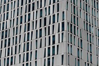 A gray building facade with windows in various shapes in Rotterdam. Original public domain image from <a href="https://commons.wikimedia.org/wiki/File:Gray_office_building_facade_(Unsplash).jpg" target="_blank" rel="noopener noreferrer nofollow">Wikimedia Commons</a>