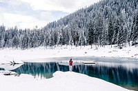 A person standing in front of a mountain pond at the Grisons canton in Switzerland. Original public domain image from Wikimedia Commons