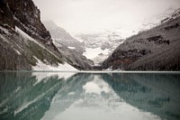 View from the clear surface of a mountain lake on a steep granite face covered in snow. Original public domain image from <a href="https://commons.wikimedia.org/wiki/File:Lake_Louise_(Unsplash).jpg" target="_blank" rel="noopener noreferrer nofollow">Wikimedia Commons</a>