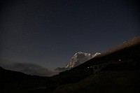 Starry night sky over the towering mountains in Nepal. Original public domain image from Wikimedia Commons