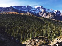 Moraine Lake in Alberta, Canada against a forest of trees and snow capped mountains. Original public domain image from Wikimedia Commons