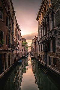 Buildings reflected in the still surface of the water in a tranquil Venice canal. Original public domain image from Wikimedia Commons