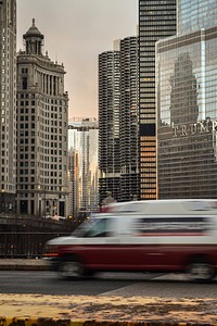 A blurry car on a bridge in a city with skyscrapers at the back. Original public domain image from <a href="https://commons.wikimedia.org/wiki/File:Downtown_bridge_(Unsplash).jpg" target="_blank" rel="noopener noreferrer nofollow">Wikimedia Commons</a>