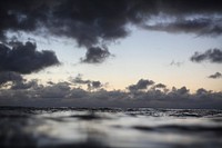The view of a stormy horizon in the evening from the ocean surface in Waimea Bay. Original public domain image from Wikimedia Commons