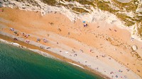 Drone aerial view of a crowded sand beach coastline at Durdle Door. Original public domain image from <a href="https://commons.wikimedia.org/wiki/File:Crowded_sand_beach_drone_view_(Unsplash).jpg" target="_blank" rel="noopener noreferrer nofollow">Wikimedia Commons</a>