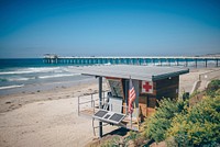 Exquisite lifeguard quarters at beach in an ocean with a boardwalk leading up to pier. Original public domain image from <a href="https://commons.wikimedia.org/wiki/File:Capture_of_Lifeguard_post_in_San_Diego_Beach_(Unsplash).jpg" target="_blank" rel="noopener noreferrer nofollow">Wikimedia Commons</a>