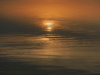 Setting sun reflected in the surface of the sea. Original public domain image from Wikimedia Commons
