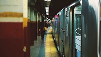 Passengers walk across the edge of the subway platform as a train opens its doors. Original public domain image from Wikimedia Commons