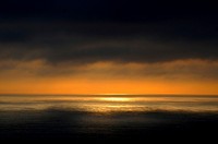 A dark and moody sunset over the ocean with yellow and orange rays on the horizon in Chile.. Original public domain image from <a href="https://commons.wikimedia.org/wiki/File:Chile_sunset._(Unsplash).jpg" target="_blank" rel="noopener noreferrer nofollow">Wikimedia Commons</a>