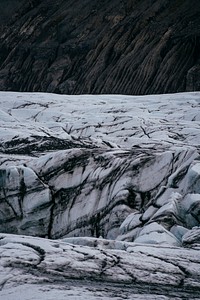 A white, icy glacier with dark crevices. Original public domain image from <a href="https://commons.wikimedia.org/wiki/File:Rugged_glacier_(Unsplash).jpg" target="_blank" rel="noopener noreferrer nofollow">Wikimedia Commons</a>