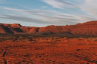 Red rock and sand in a barren desert terrain. Original public domain image from Wikimedia Commons
