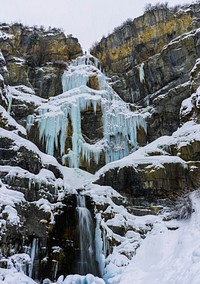 Frozen icy waterfall cascades down rocky cliff. Original public domain image from <a href="https://commons.wikimedia.org/wiki/File:Frozen_1_(Unsplash).jpg" target="_blank" rel="noopener noreferrer nofollow">Wikimedia Commons</a>