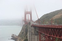 Long shot of misty Golden Gate Bridge in San Francisco with busy daytime traffic. Original public domain image from Wikimedia Commons