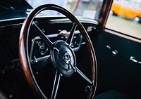Old vintage car interior with the wooden frame steering wheel. Original public domain image from <a href="https://commons.wikimedia.org/wiki/File:Drive_me_(Unsplash).jpg" target="_blank" rel="noopener noreferrer nofollow">Wikimedia Commons</a>