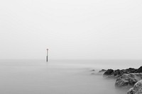 Isolated sign in the middle of a foggy sea near rocks. Original public domain image from Wikimedia Commons