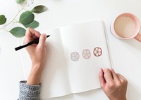 Woman drawing doodle elements in a notebook