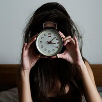 Messy hair girl wakes up with a clock