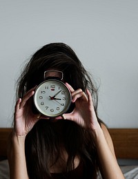 Messy hair girl wakes up with a clock
