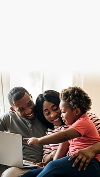 Happy black family and toddler pointing at a laptop screen black space