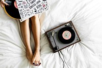 Woman listening to music with vinyl disk turntable
