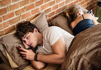 Caucasian man using mobile phone in bed