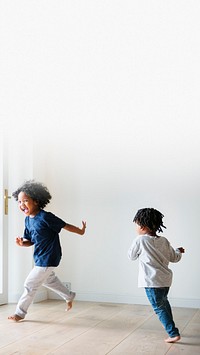 Two black kids playing and chasing each other in an empty room design space