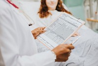 Doctor reading the daily medical report to a patient