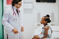 Pediatrician talking to his little patient