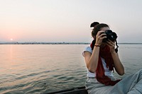Female photographer sitting on a boat on the River Ganges