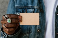 Hand with rings holding a name card