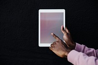 Hand holding a digital tablet on black background