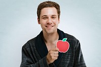 Portrait of a handsome man in a dark rope showing a red apple symbol