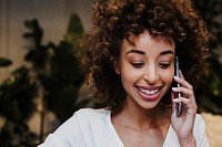 Cheerful woman talking on the phone in a cafe